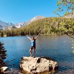 Hiker celebrating the view at the Emerald Lake on the Five Lakes Trail of Rocky Mountain National Park in Estes Park