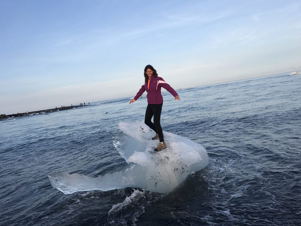 Hiker standing on an iceberg in the iceberg lagoon in Iceland