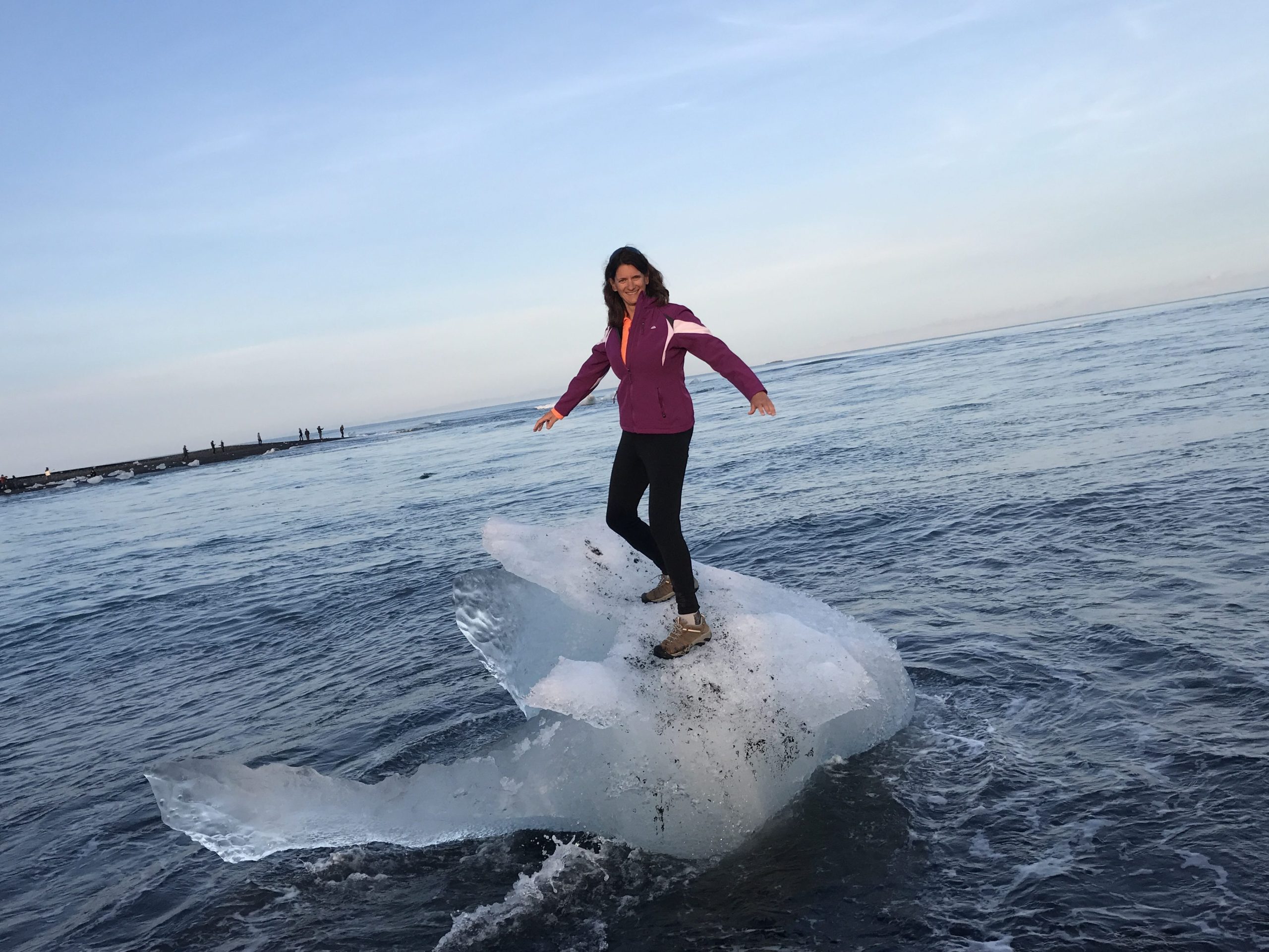 Hiker standing on an iceberg in the iceberg lagoon in Iceland