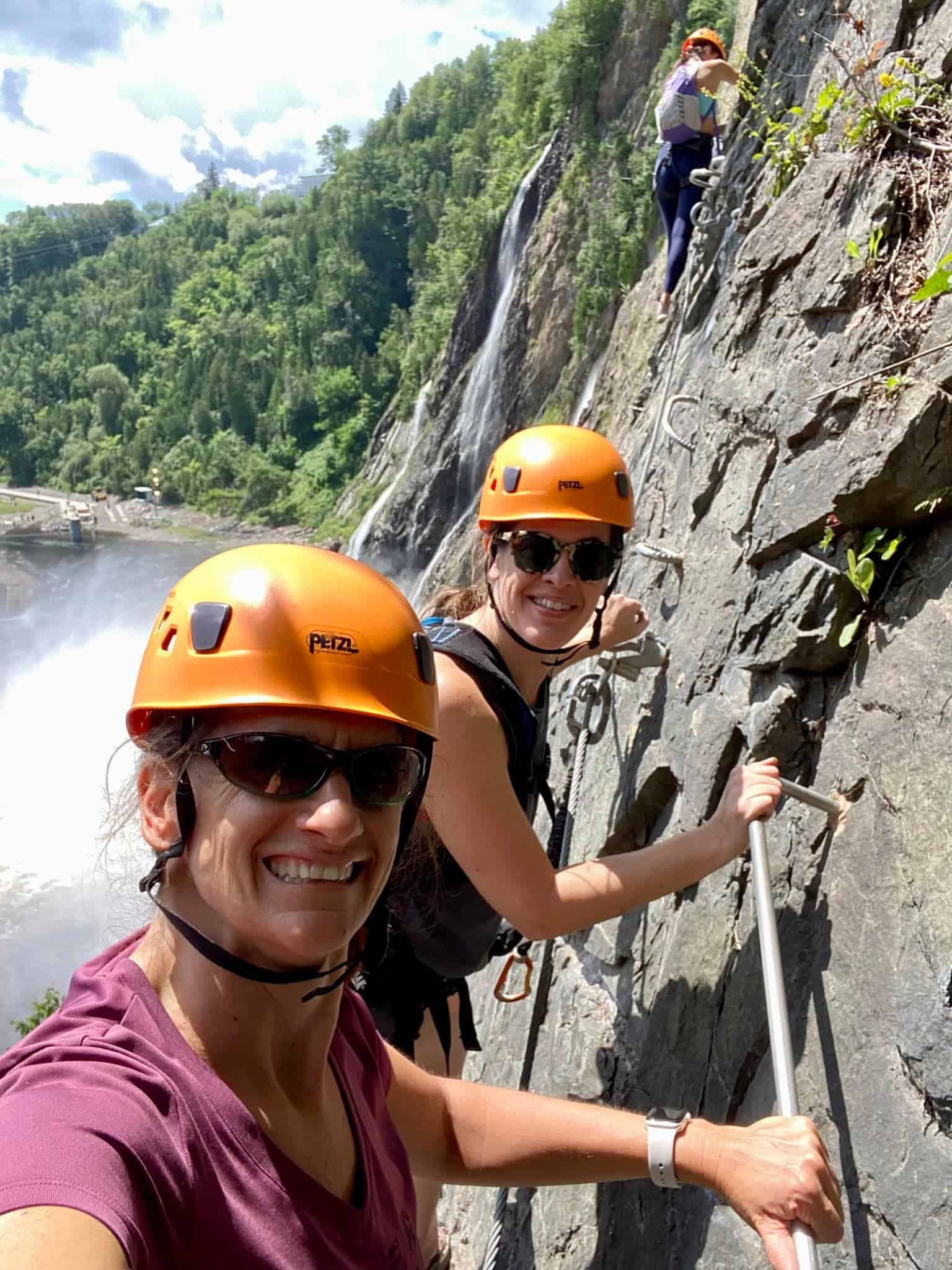 Adventure travelers climb the via ferrata or iron rungs at montmorency falls in quebec city, Canada