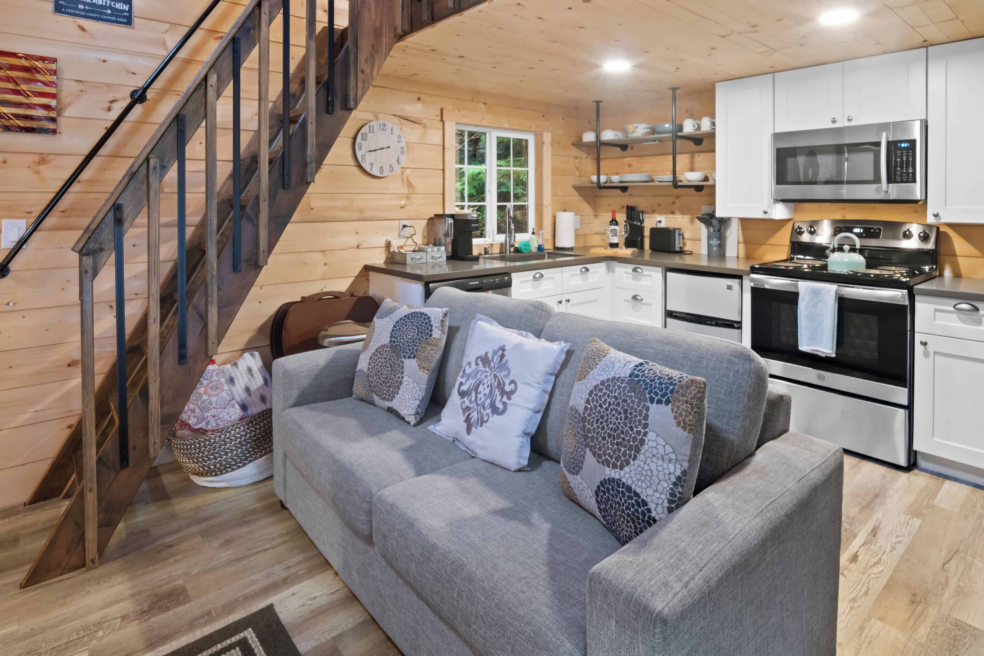 The interior of a Tiny Cabin near Mt Rainier National Park, showing the couch, kitchen and stairs to the loft