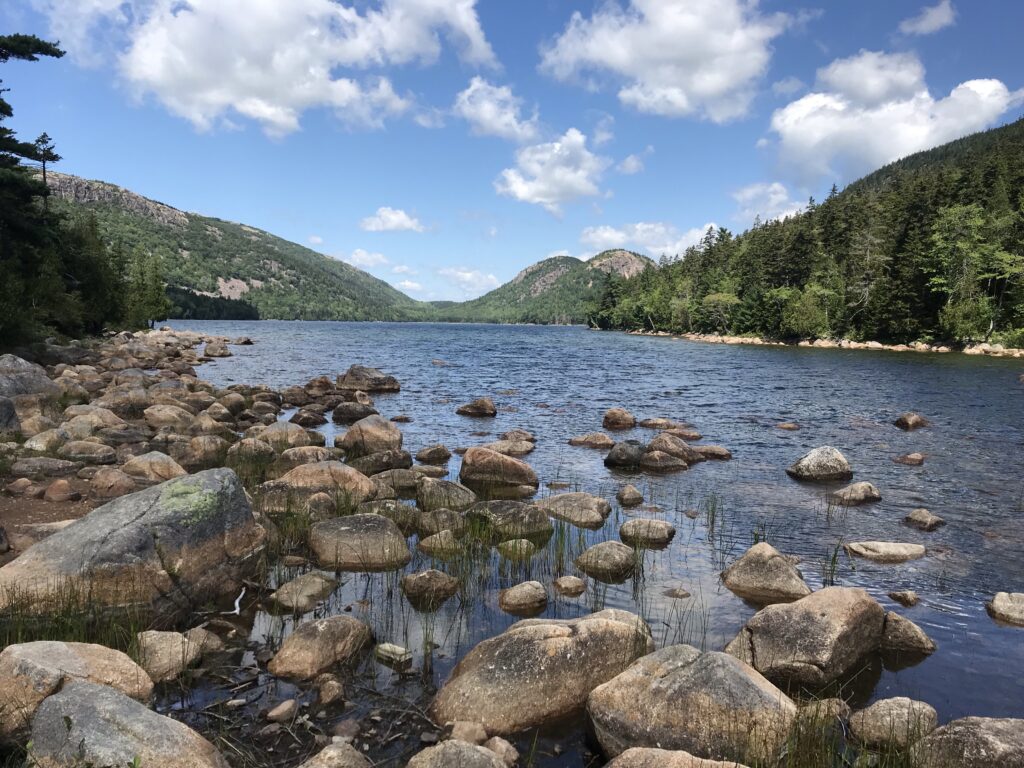 View of rocks and mountain reflection at  Jordan Pond on Mount Desert Island in Acadia National Park