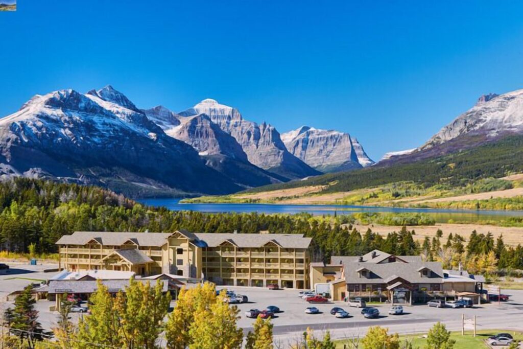 Aerial shot of St. Mary Village hotel and the snow-covered mountains of Glacier National Park in the background